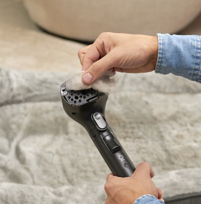 una persona che pulisce la spazzola dai peli di un animale