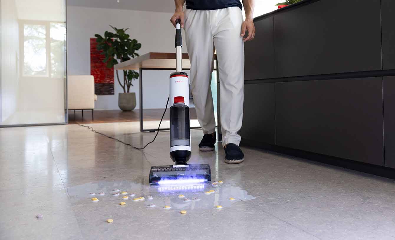 L'immagine mostra Polti Rollysteam in azione su un pavimento sporco di latte e cereali